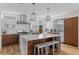 Modern kitchen with stainless steel appliances, wood cabinets, a large island with seating and designer lighting at 1845 W 33Rd Ave, Denver, CO 80211