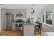 Modern kitchen features stainless steel appliances, stone countertops, a breakfast bar, and modern pendant lighting at 1845 W 33Rd Ave, Denver, CO 80211