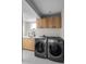 Laundry room with wooden cabinets, white counters, and gray washer and dryer at 1845 W 33Rd Ave, Denver, CO 80211