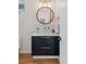 Stylish powder room featuring modern vanity, fixtures, wood floors, and a round wood-framed mirror at 1845 W 33Rd Ave, Denver, CO 80211
