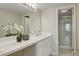 Bathroom with white countertops, cabinetry and a shower behind a glass door at 9995 E Harvard Ave # 155, Denver, CO 80231