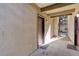 Covered condo entrance with a secure door and gravel landscaping, blending convenience with a touch of natural charm at 9995 E Harvard Ave # 155, Denver, CO 80231
