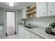 Bright kitchen featuring granite countertops, white cabinets, and floating wood shelves at 9995 E Harvard Ave # 155, Denver, CO 80231