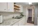 Modern kitchen featuring granite countertops, white cabinets, and stainless steel sink at 9995 E Harvard Ave # 155, Denver, CO 80231