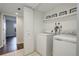 Bright laundry area features modern appliances and a shelf, seamlessly blending functionality with a clean aesthetic at 9995 E Harvard Ave # 155, Denver, CO 80231