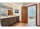 Bright bathroom with dual sinks and an open doorway to the bedroom at 5394 S Valdai Way, Aurora, CO 80015