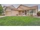 Well-manicured front yard featuring a home with a charming porch and attached garage at 5394 S Valdai Way, Aurora, CO 80015