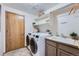 Organized laundry room with modern washer and dryer, sink, and ample storage shelving at 5394 S Valdai Way, Aurora, CO 80015