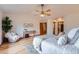 Cozy bedroom featuring a ceiling fan, light wood floors, and a comfortable seating area at 5394 S Valdai Way, Aurora, CO 80015