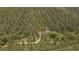 Aerial view of the property showcasing the lush, dense surrounding forest and the home at 27756 Troublesome Gulch Rd, Evergreen, CO 80439