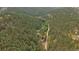 Aerial view of the property nestled in the forest showing the buildings and grounds at 27756 Troublesome Gulch Rd, Evergreen, CO 80439