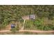 Aerial view of the property showing the house, barn, and creek nestled in a lush green forest at 27756 Troublesome Gulch Rd, Evergreen, CO 80439