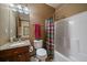 Functional bathroom with a granite-topped vanity, toilet and shower with decorative curtain at 27756 Troublesome Gulch Rd, Evergreen, CO 80439