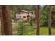 Exterior of a home featuring a spacious deck with trees and serene landscaping at 27756 Troublesome Gulch Rd, Evergreen, CO 80439