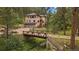 Charming two-story home with a bridge leading to the property and a three car garage at 27756 Troublesome Gulch Rd, Evergreen, CO 80439