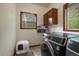 Modern laundry room with large capacity washer and dryer with natural light from two windows at 27756 Troublesome Gulch Rd, Evergreen, CO 80439