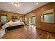 Large main bedroom with hardwood floors, natural light and windows offering wooded views at 27756 Troublesome Gulch Rd, Evergreen, CO 80439