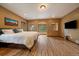 Spacious main bedroom with hardwood floors, neutral walls, and picturesque windows with wooded views at 27756 Troublesome Gulch Rd, Evergreen, CO 80439