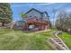 Expansive backyard with a large deck, hot tub, and mature landscaping at 7411 S Curtice Ct, Littleton, CO 80120