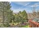 Scenic view from backyard featuring lush greenery, mature trees, and partial mountain views at 7411 S Curtice Ct, Littleton, CO 80120