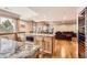 Finished basement featuring a stylish wet bar with granite countertops, seating, and lovely wood floors at 7411 S Curtice Ct, Littleton, CO 80120