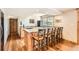 Finished basement featuring a stylish wet bar with granite countertops, seating for five, and lovely wood floors at 7411 S Curtice Ct, Littleton, CO 80120