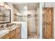 Elegant bathroom featuring a glass-enclosed shower, granite countertop vanity, and wood cabinets at 7411 S Curtice Ct, Littleton, CO 80120