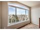 Bright bedroom featuring a large window with beautiful views of the surrounding neighborhood and distant mountains at 7411 S Curtice Ct, Littleton, CO 80120