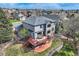 Aerial view of a two-story home featuring a spacious deck and beautifully landscaped backyard at 7411 S Curtice Ct, Littleton, CO 80120