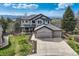 Stunning two-story home features a three-car garage, manicured lawn, and mountain views at 7411 S Curtice Ct, Littleton, CO 80120