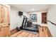 Home gym featuring an elliptical, weights, natural light, and hardwood floors at 7411 S Curtice Ct, Littleton, CO 80120