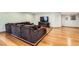 Finished basement living room featuring a comfortable sectional couch, hardwood floors, and a flatscreen television at 7411 S Curtice Ct, Littleton, CO 80120
