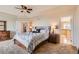 This spacious bedroom has a ceiling fan, carpet and a door to the bathroom suite at 7411 S Curtice Ct, Littleton, CO 80120