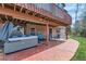 Relaxing backyard patio with a hot tub and comfortable seating underneath a spacious elevated deck at 7411 S Curtice Ct, Littleton, CO 80120