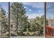 A scenic view of mature trees and sky from the home's large picture window at 7411 S Curtice Ct, Littleton, CO 80120