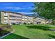 Attractive apartment building exterior with well-maintained lawn, landscaping and blue sky at 635 S Alton Way # 6A, Denver, CO 80247