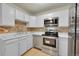 Bright kitchen with stone tile backsplash, stainless appliances, and plenty of cabinet space at 635 S Alton Way # 6A, Denver, CO 80247