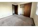 Bedroom featuring a standard closet with sliding doors and neutral carpet at 17969 E Brown Pl, Aurora, CO 80013