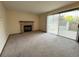 Inviting living area with a brick fireplace, plush carpeting, and a large sliding glass door at 17969 E Brown Pl, Aurora, CO 80013
