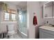 Updated bathroom featuring a glass-enclosed shower, gray vanity and marble floor at 2855 Albion St, Denver, CO 80207