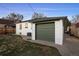 View of a house and its garage with a small yard and patio area at 2855 Albion St, Denver, CO 80207