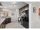 Modern kitchen with stainless appliances, dark cabinets, and a view of the backyard at 2855 Albion St, Denver, CO 80207