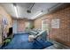 Finished garage space with exposed brick, plush blue carpet, and comfortable seating arrangement at 2855 Albion St, Denver, CO 80207