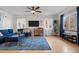 Cozy living room with a blue sofa, ceiling fan, and ample natural light at 2855 Albion St, Denver, CO 80207