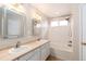 Bathroom featuring double sinks, a shower-tub combo, and bright lighting at 9450 Troon Village Dr, Lone Tree, CO 80124