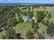Aerial view of a home nestled among lush trees with a long driveway, set in a scenic landscape at 11824 E Basswood Ln, Franktown, CO 80116