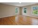 Bright bedroom with hardwood floors and three windows offering ample natural light at 11824 E Basswood Ln, Franktown, CO 80116