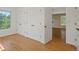 Bedroom showing hardwood floors, three white closets, and a doorway at 11824 E Basswood Ln, Franktown, CO 80116