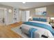 A bedroom offers hardwood floors, a large bed with blue accents, and an ensuite bathroom at 11824 E Basswood Ln, Franktown, CO 80116