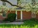 Inviting brick home featuring a wooden front door with sidelights and mature landscaping at 11824 E Basswood Ln, Franktown, CO 80116